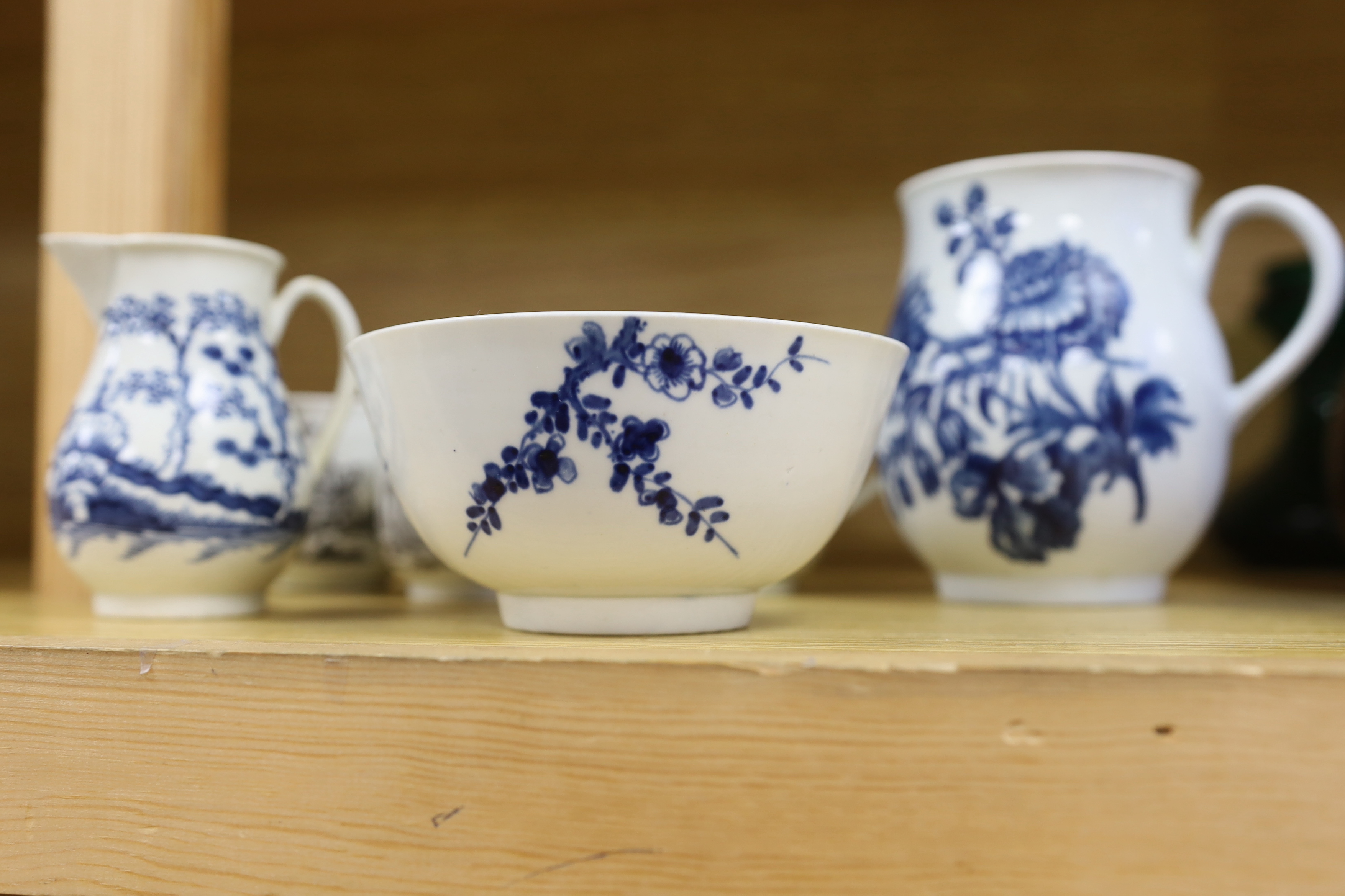 18th century Worcester comprising two floral bowls, two jugs, and three transfer printed cups, the largest 15cm in diameter (7)